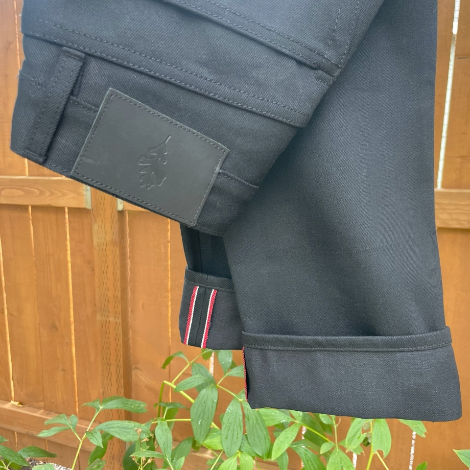 Folded Black selvedge denim jeans made in USA with Native American Ginew Leather Patch 