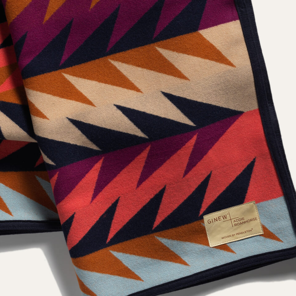 Close up of Native American 100% wool blanket in blue, brown, plum, black and tan made in USA tag